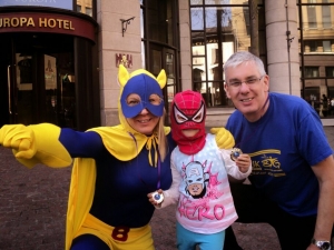 Sharon Mileen and Donald Cairnduff receive their abseiling medals from a masked Leah Carter